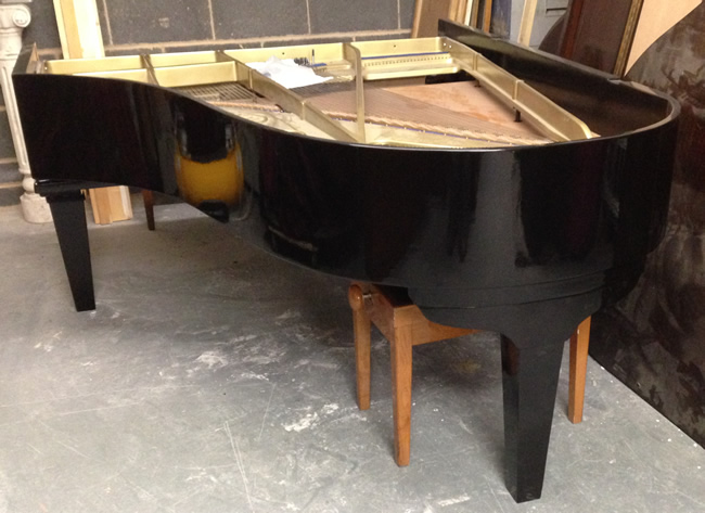 Piano body after spraying black prior to buffing.